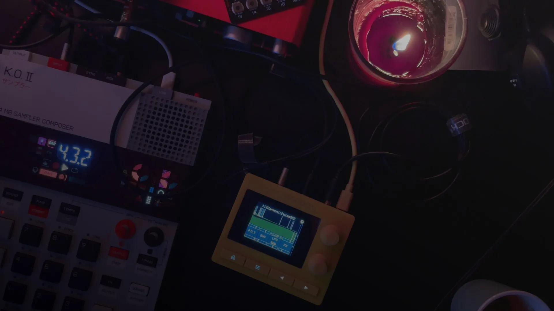 The synthesizers from above, in the dark, a candle beside them